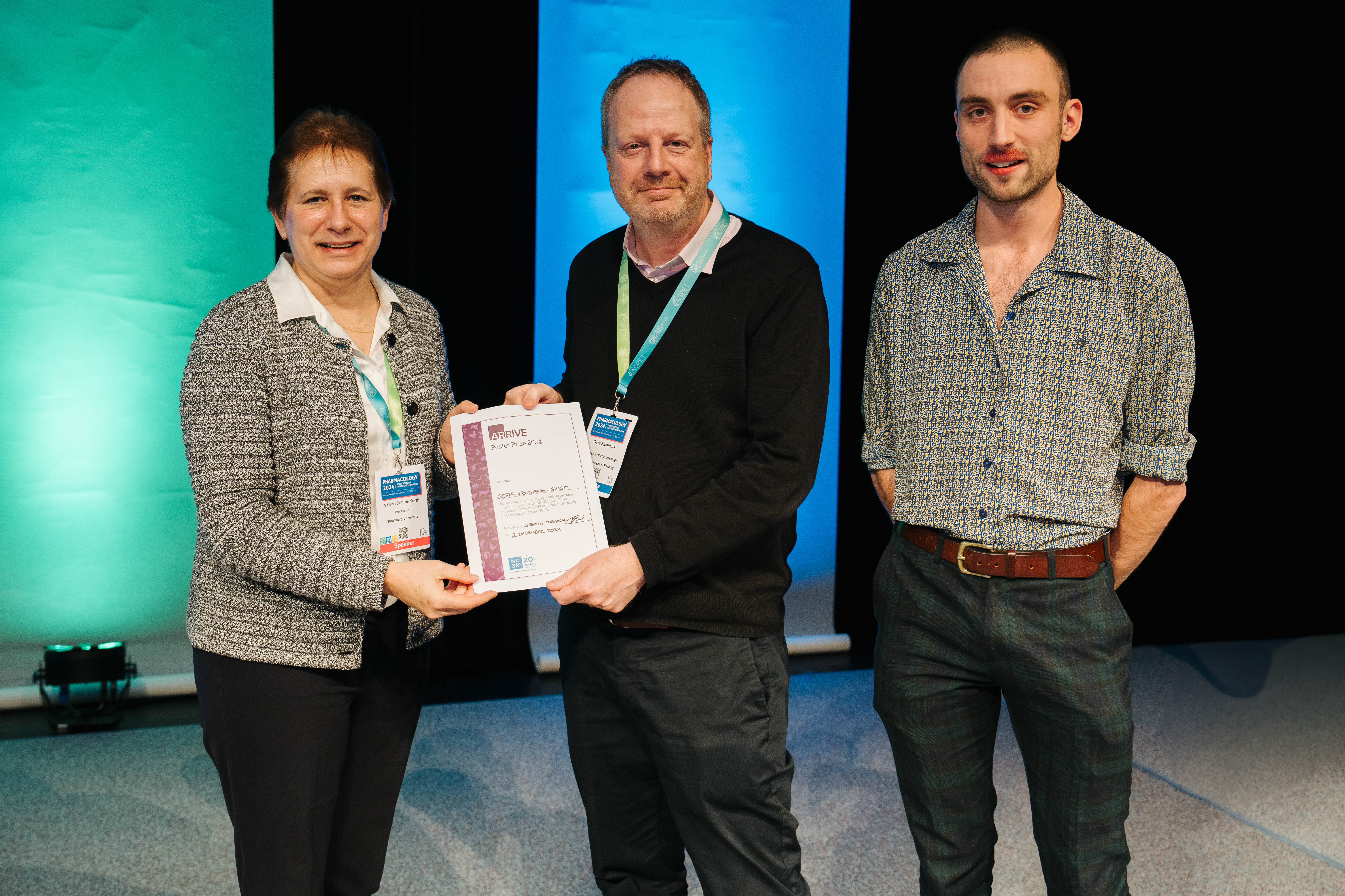 An image of Proffessor Stephen's accpeting the ARRIVE poster Prize at Pharmacology 24, with BPS and NC3Rs representative either side